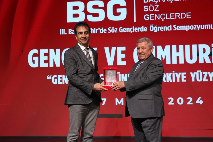 A plaque was presented to Sönmez Çelik, Head of the Ibn Haldun University Library Department, at the 'III. Başakşehir Söz Gençlerde Öğrenci' Symposium